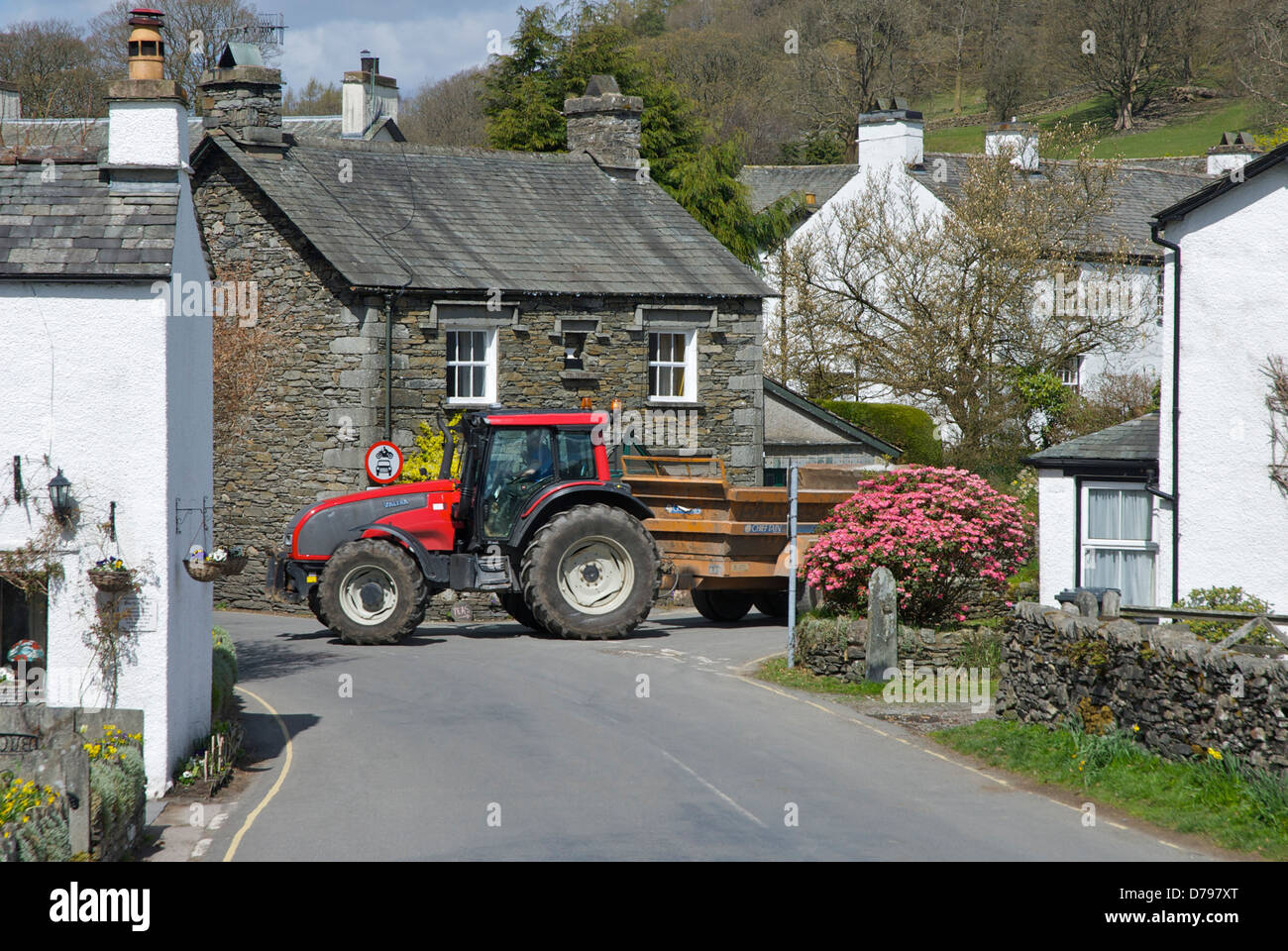 Il trattore e il rimorchio nel villaggio di Near Sawrey, Parco Nazionale del Distretto dei Laghi, Cumbria, England Regno Unito Foto Stock