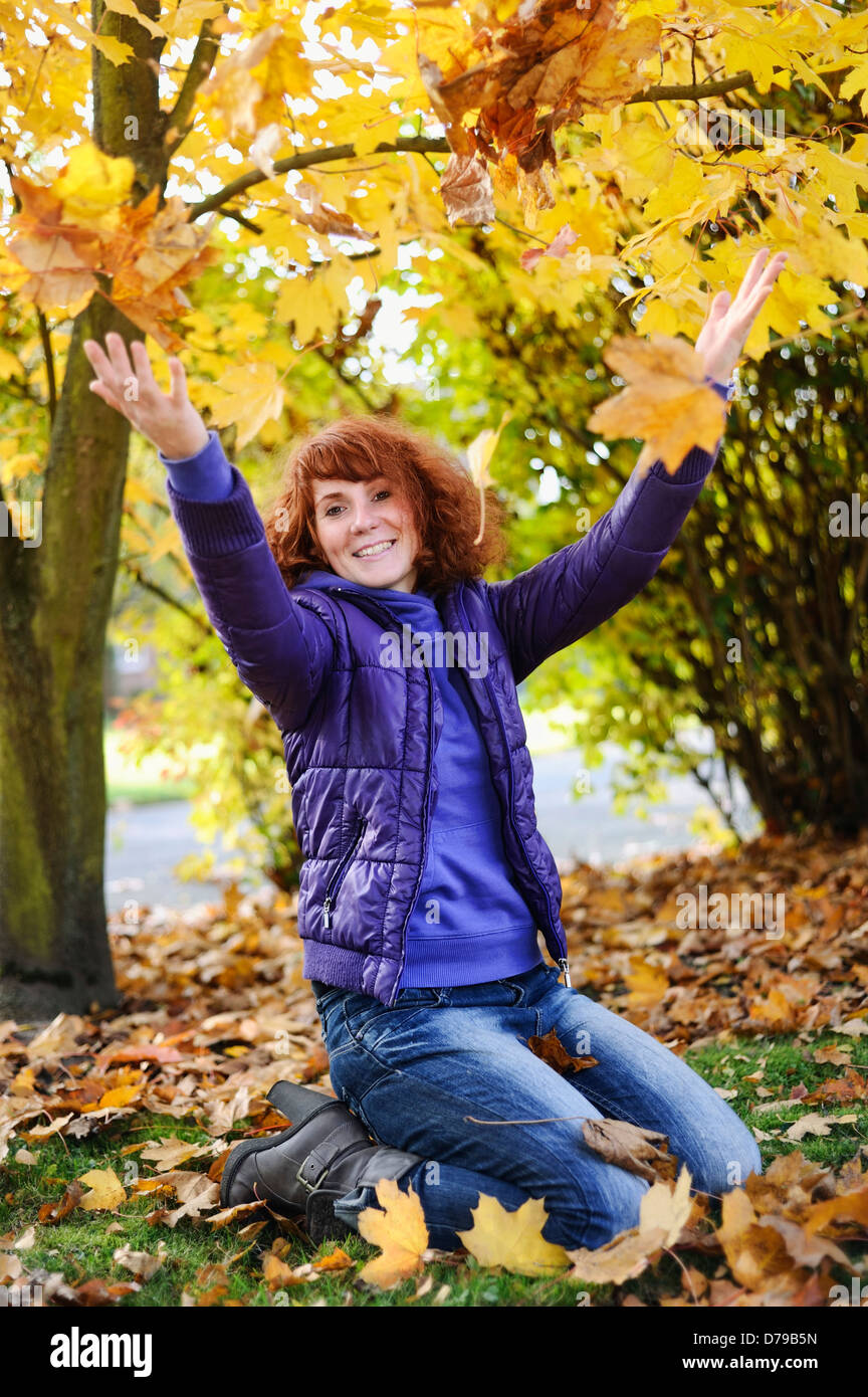 Donna felice con fogliame di autunno , Lebensfrohe Frau mit Herbstlaub Foto Stock