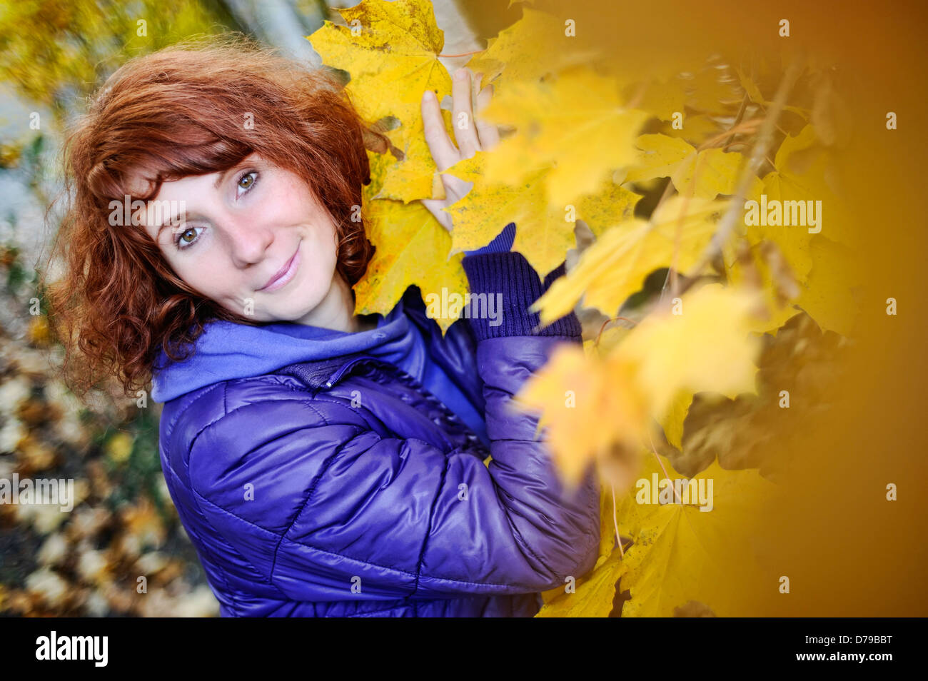 Donna felice nel fogliame di autunno , Fröhliche Frau im Herbstlaub Foto Stock