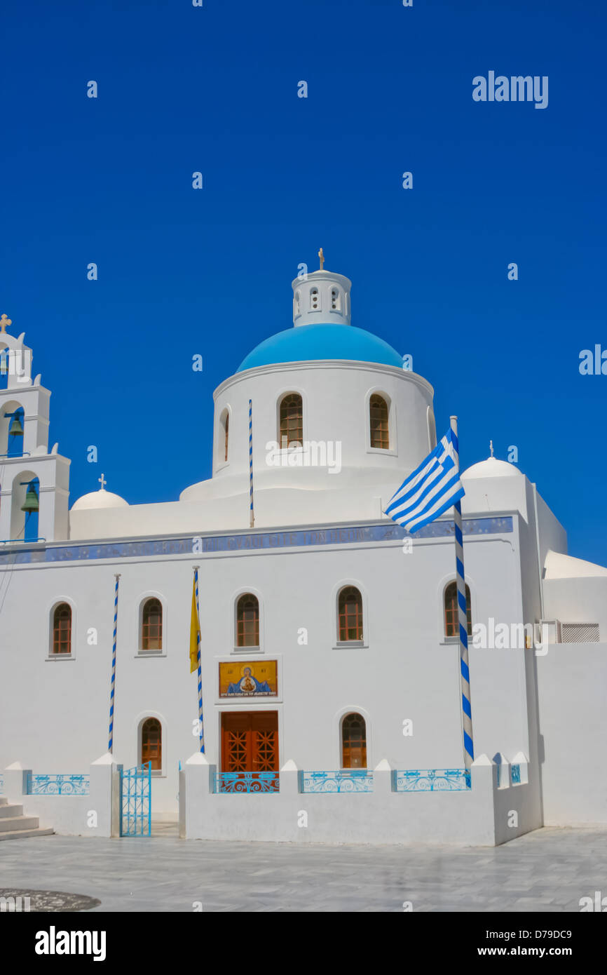 Bella bianca torre campanaria della chiesa greca sull isola di Santorini in Oia, Grecia. E la piazza con la Grecia national fla Foto Stock