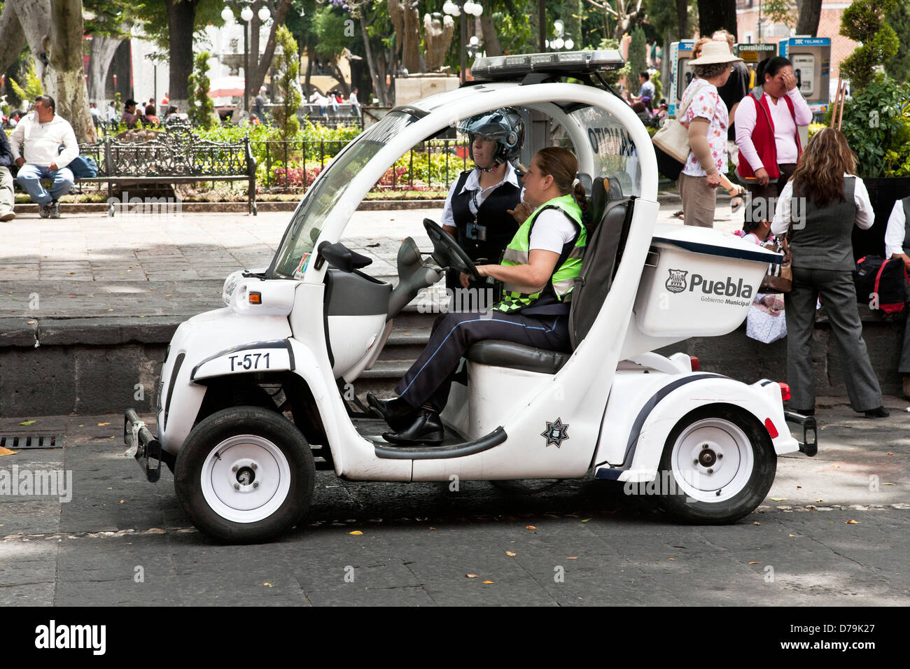 2 donne funzionari di polizia stradale con piccola elettrica municipale di veicolo parcheggiato di fianco a Puebla Zocalo sulla soleggiata giornata di primavera il Messico Foto Stock