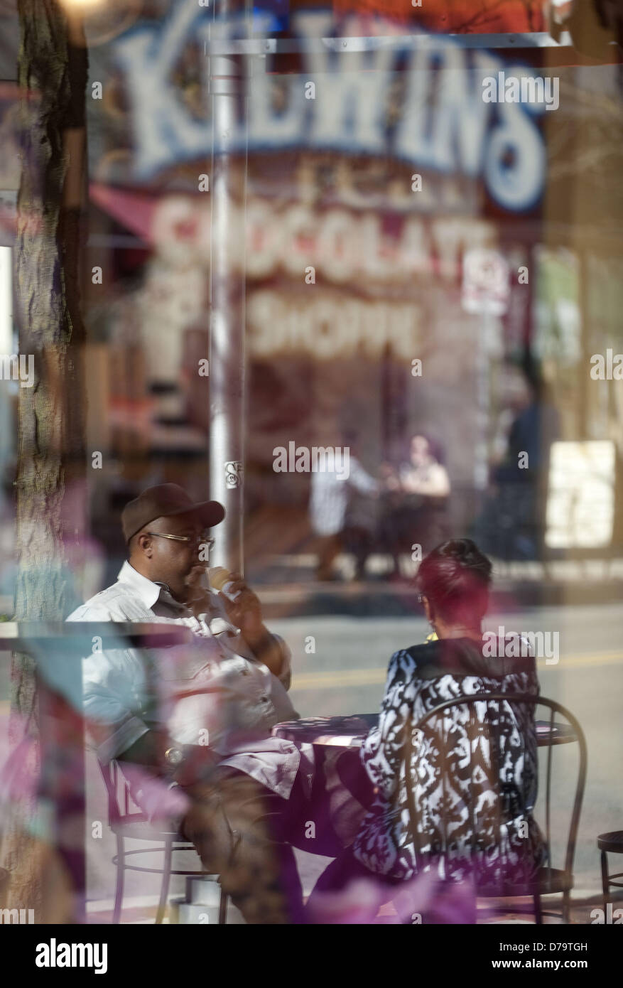 1 maggio 2013 - Ann Arbor, Michigan, Stati Uniti - Una riflessione nella finestra di cioccolato Kilwins Shoppe mostra due persone a mangiare il gelato nel centro cittadino di Ann Arbor, MI a maggio 2013. (Credito Immagine: © Mark Bialek/ZUMAPRESS.com) Foto Stock