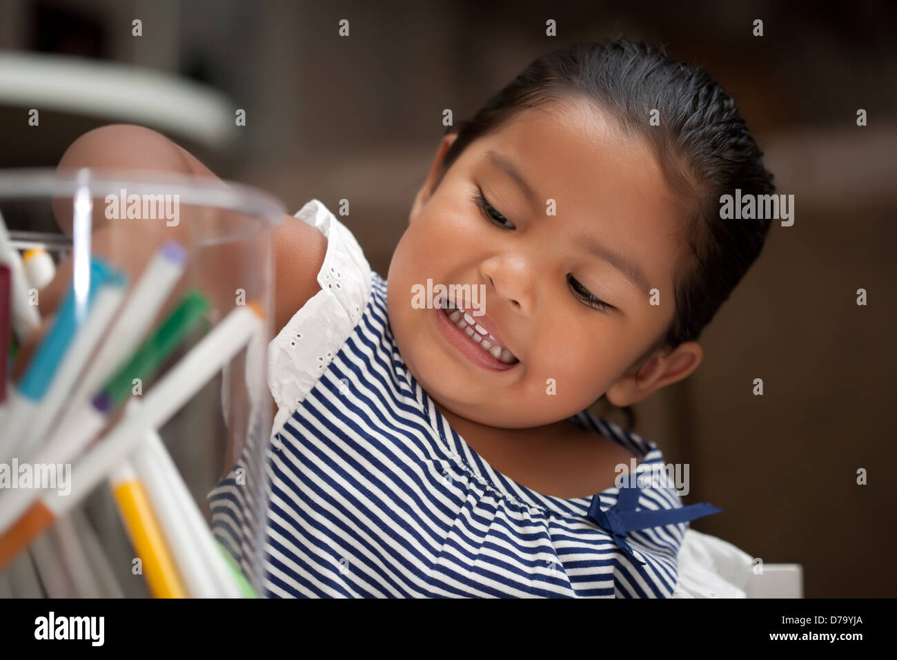 Il Toddler raggiungendo per marcatori colorati Foto Stock