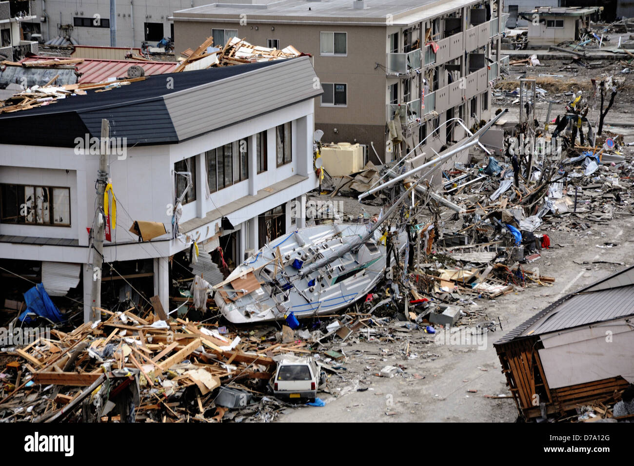 Barca a vela tra i detriti Dopo terremoto tsunami Foto Stock
