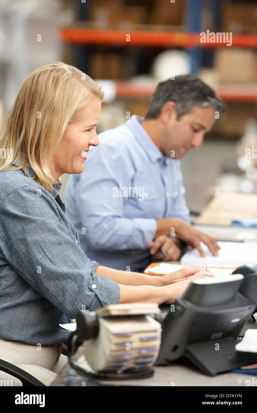 Colleghi di lavoro lavorare alla scrivania in magazzino Foto Stock