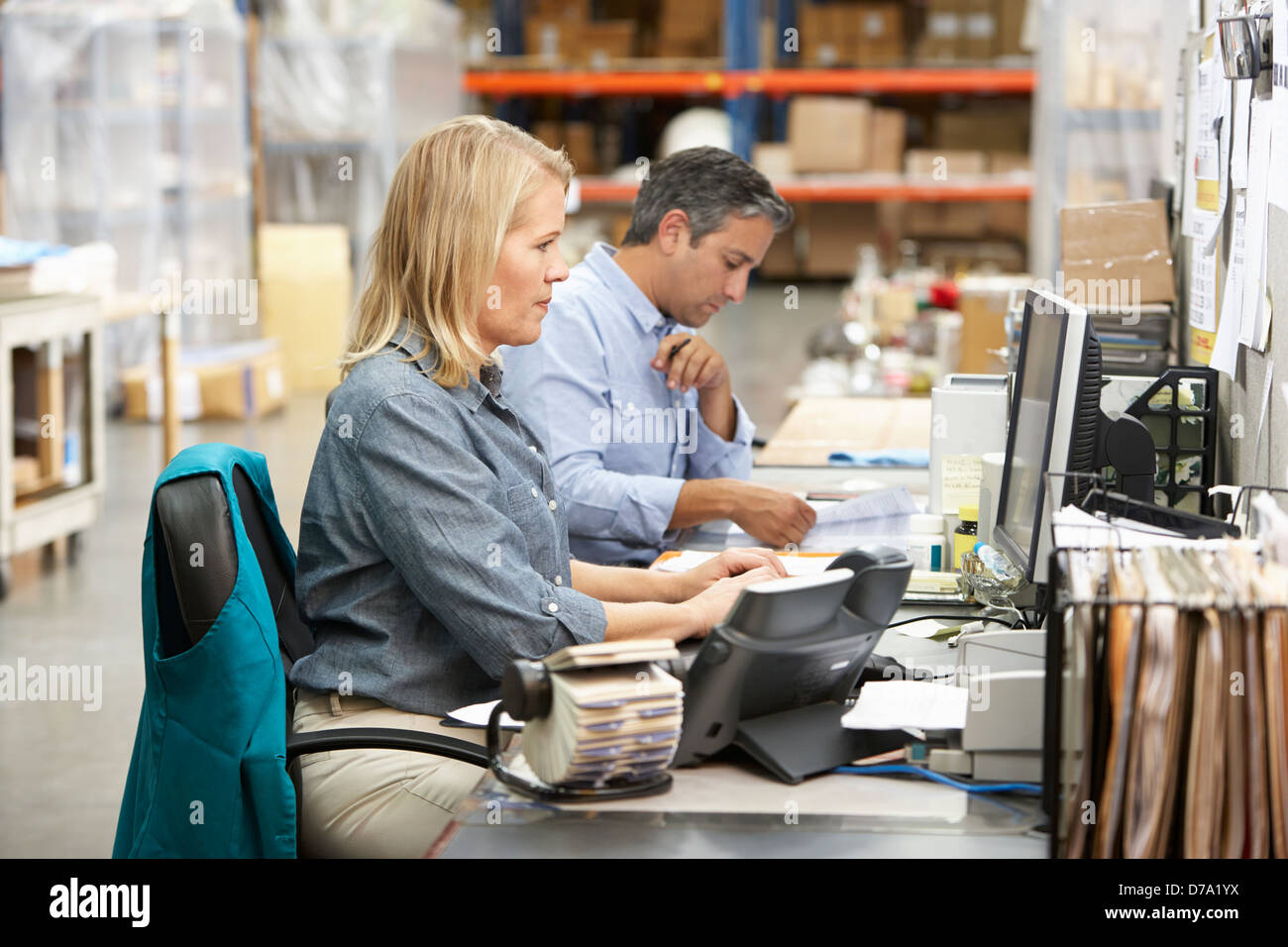 Colleghi di lavoro lavorare alla scrivania in magazzino Foto Stock