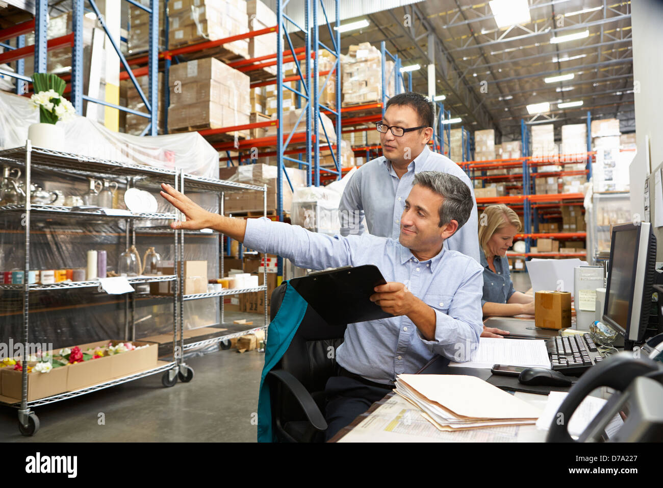 Colleghi di lavoro lavorare alla scrivania in magazzino Foto Stock