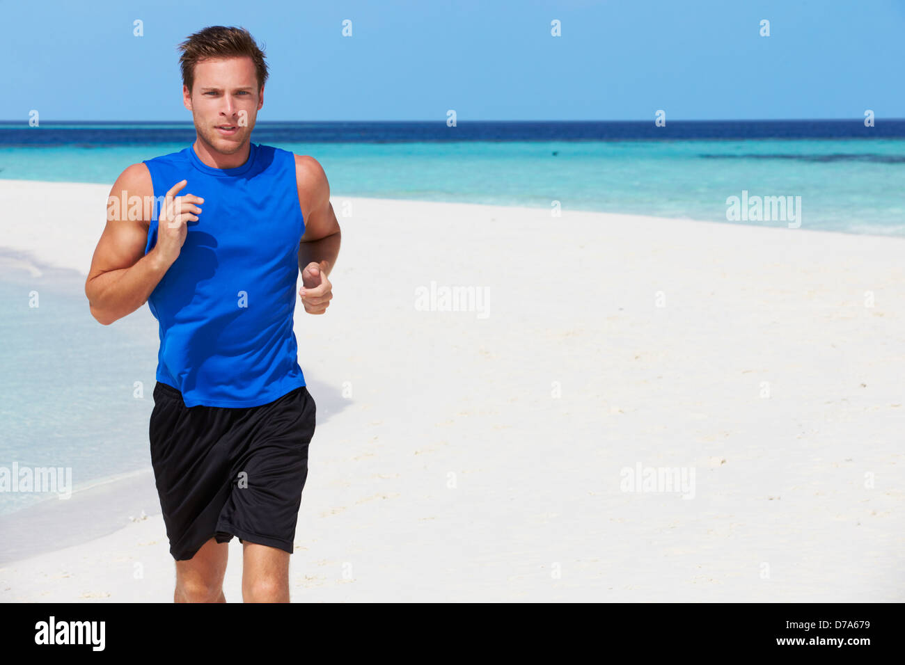 Uomo che corre sulla bellissima spiaggia Foto Stock