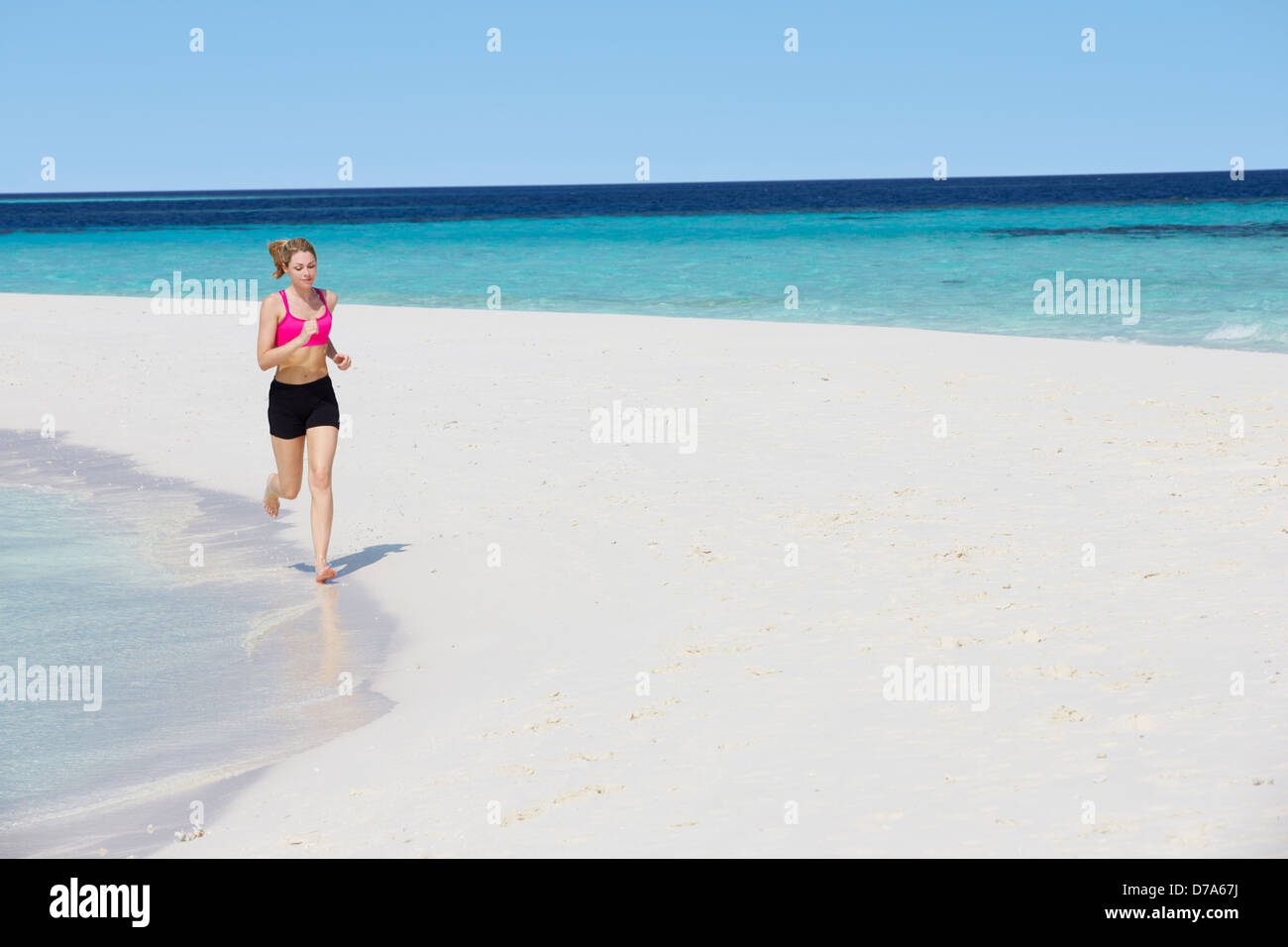 La donna in esecuzione sulla bellissima spiaggia Foto Stock