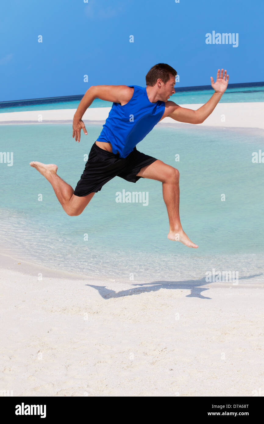 L'uomo esercita sulla bellissima spiaggia Foto Stock