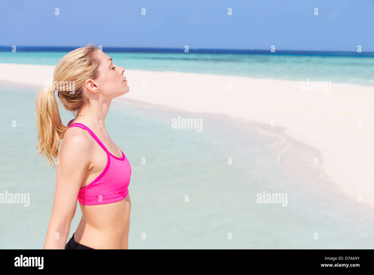 Donna meditando sulla bellissima spiaggia Foto Stock