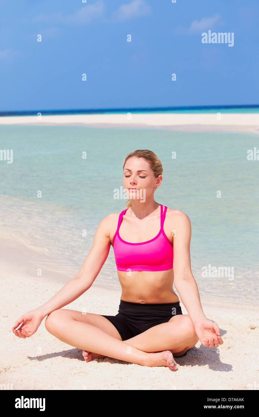 Donna meditando sulla bellissima spiaggia Foto Stock