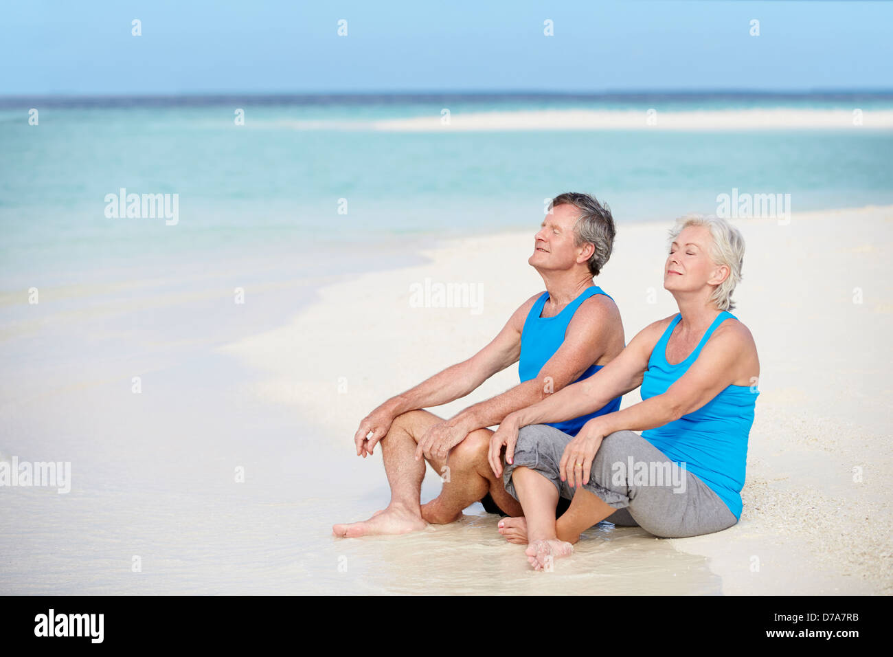 Coppia senior in abbigliamento sportivo relax sulla splendida spiaggia Foto Stock