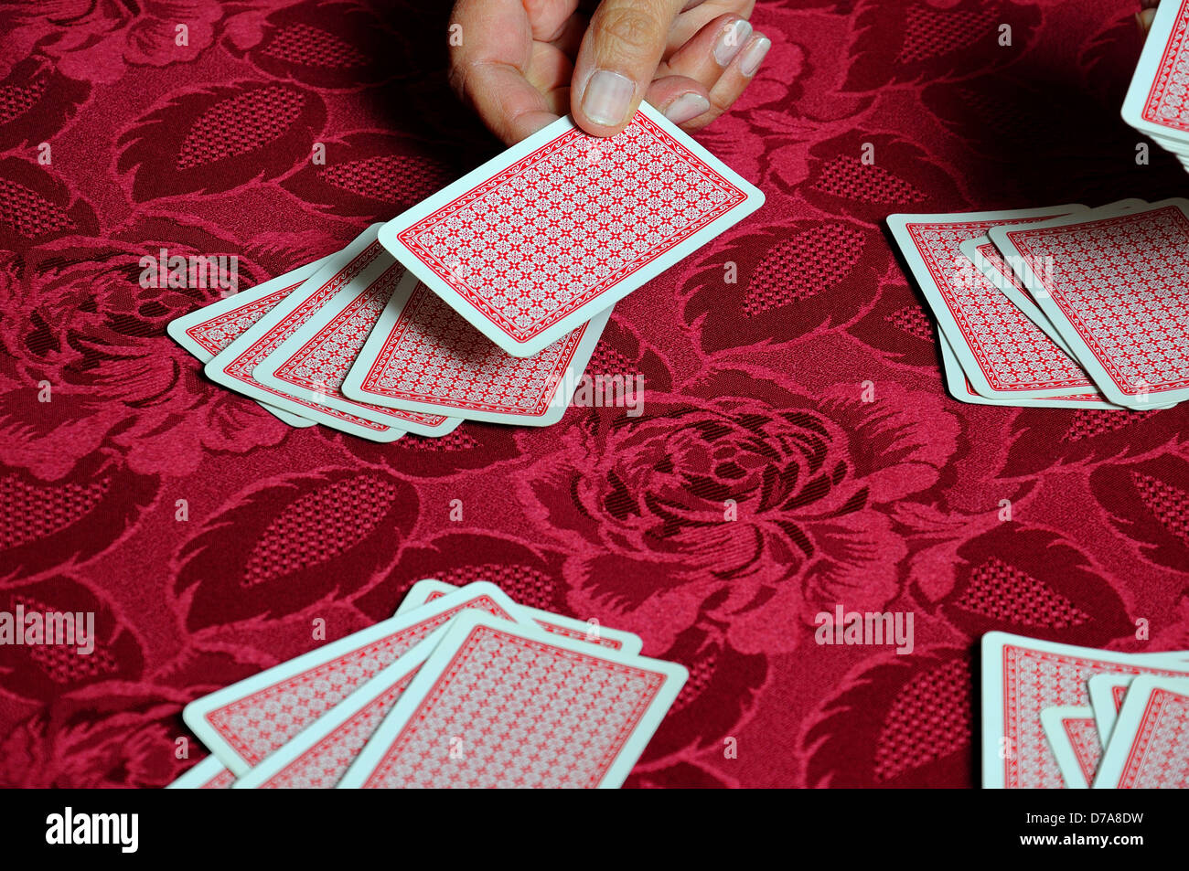 Donna che tratta un pacchetto di carte da gioco. Foto Stock