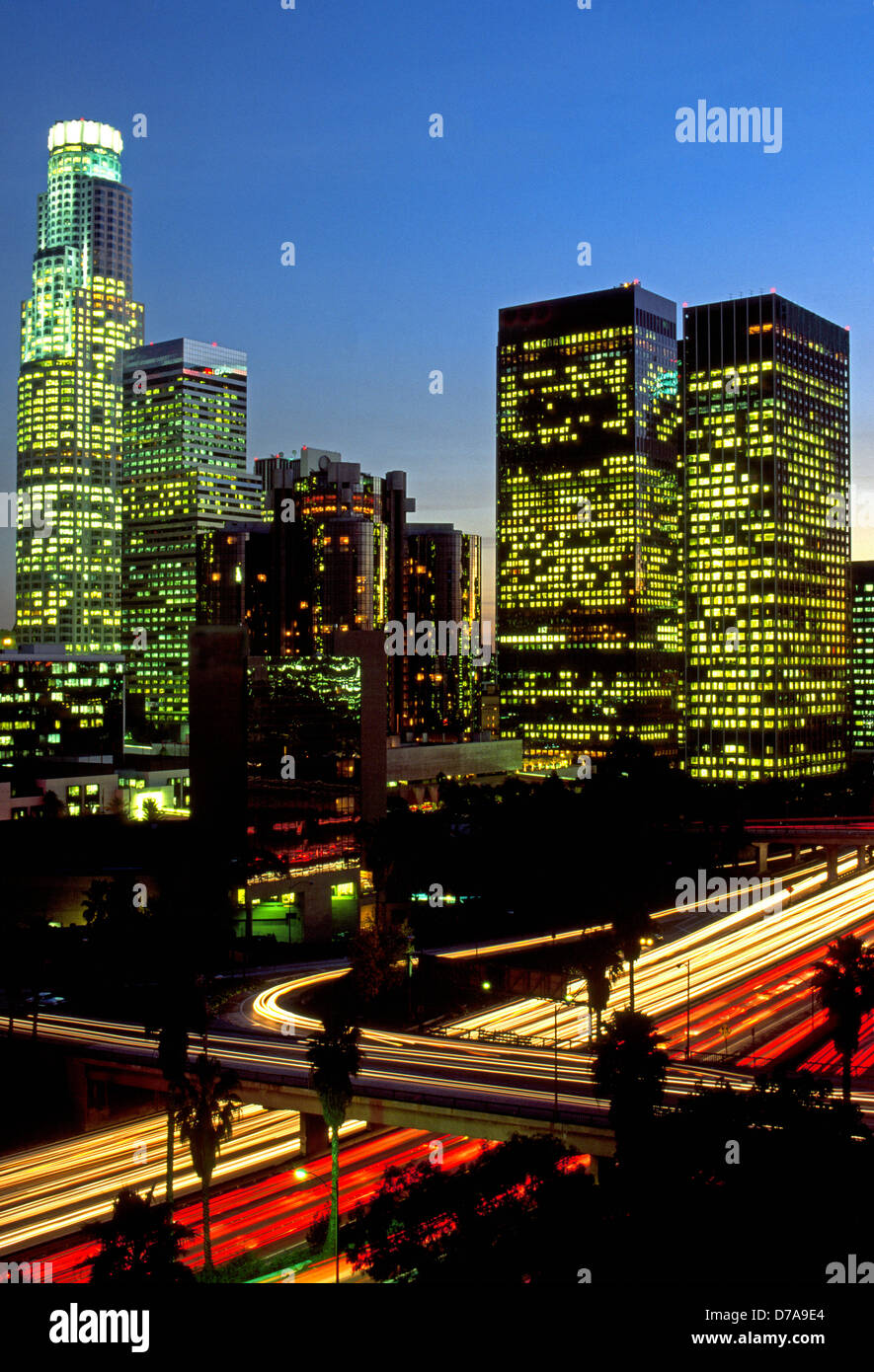 Lo skyline del centro cittadino di Los Angeles, California, USA, si illumina al tramonto con le luci di edifici per uffici e la superstrada di traffico. Foto Stock