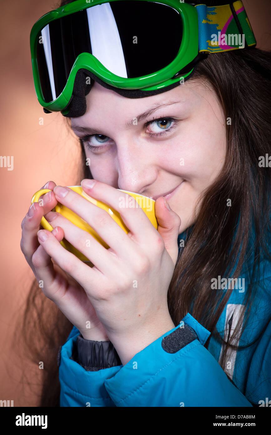 Giovani femmine snowboarder con una tazza di una bevanda calda Foto Stock