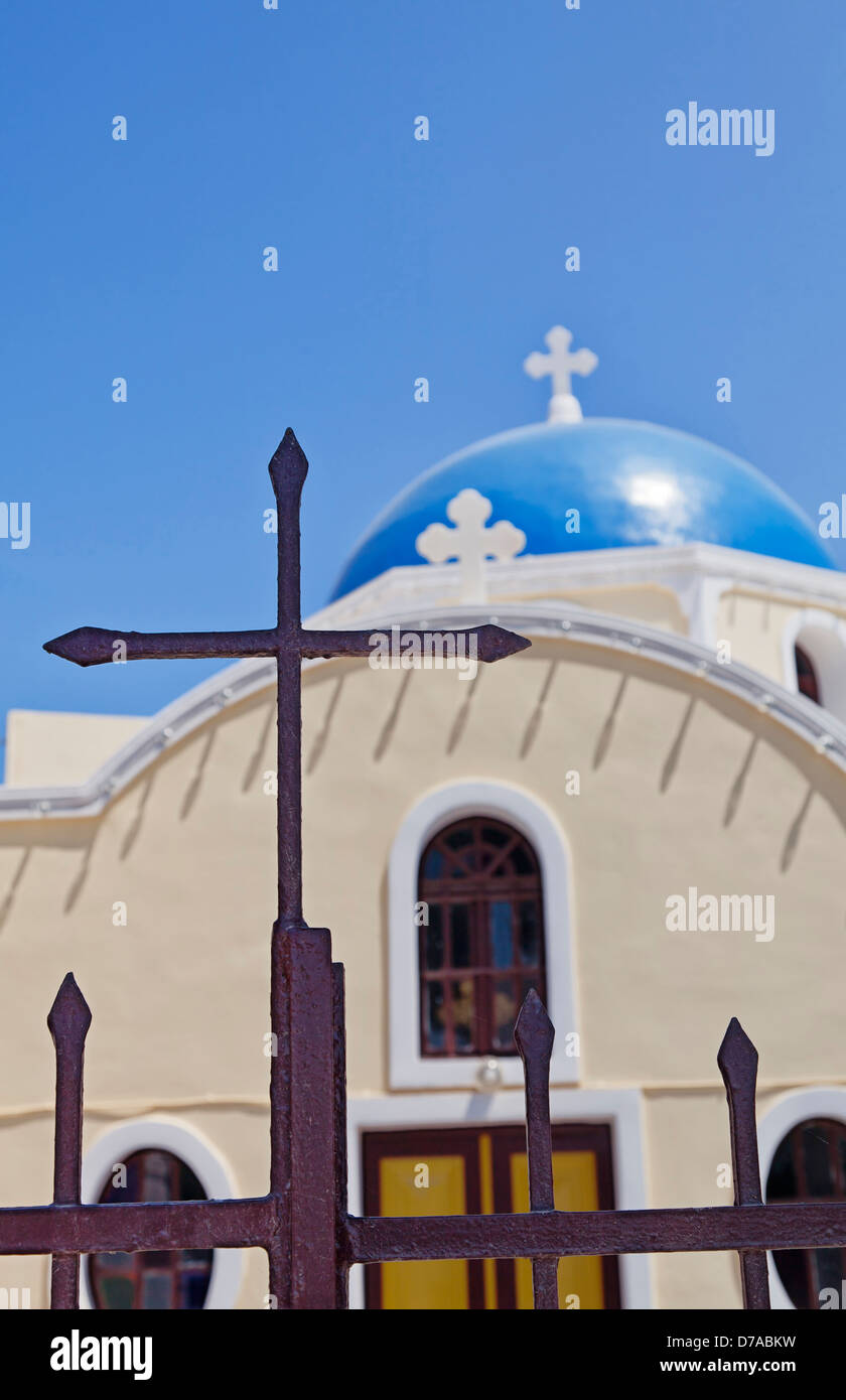 Una immagine di una cupola blu chiesa sull'isola greca di Santorini con la messa a fuoco in primo piano cancelli in ferro. Foto Stock