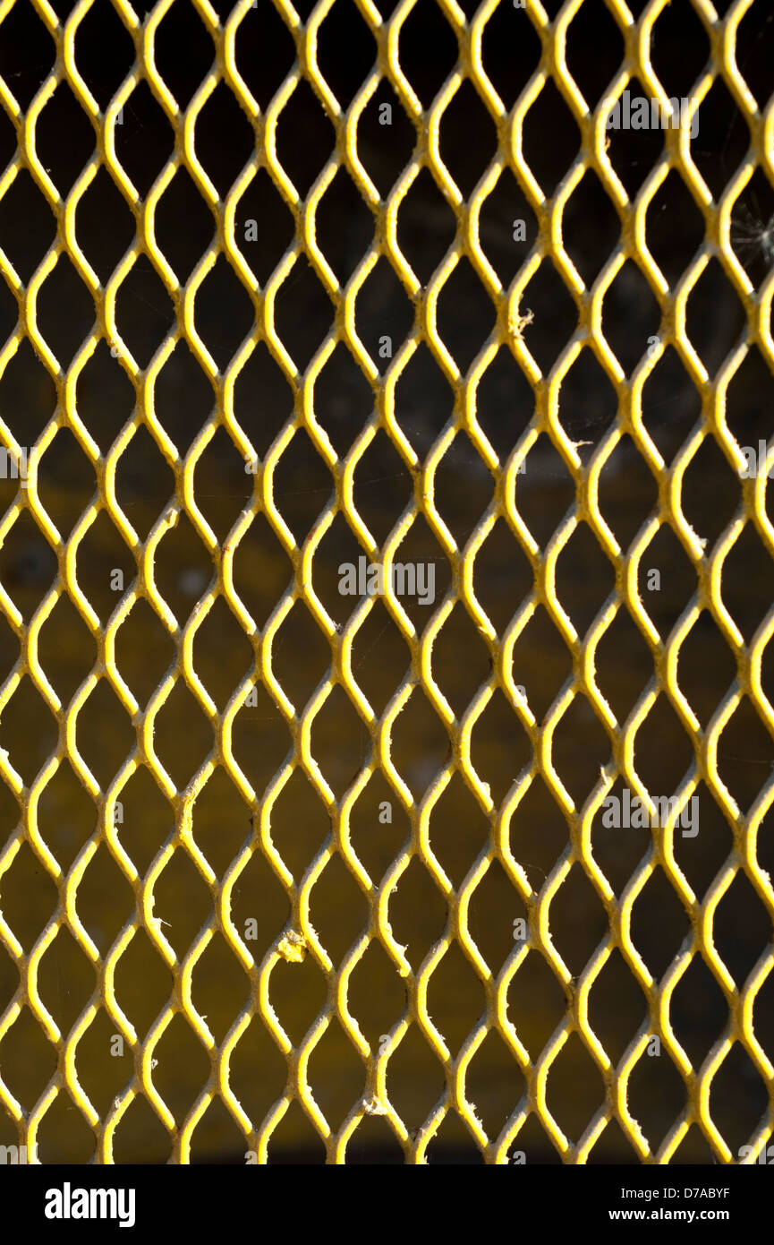 Acciaio giallo scherma pattern ripetitivo sullo sfondo Foto Stock