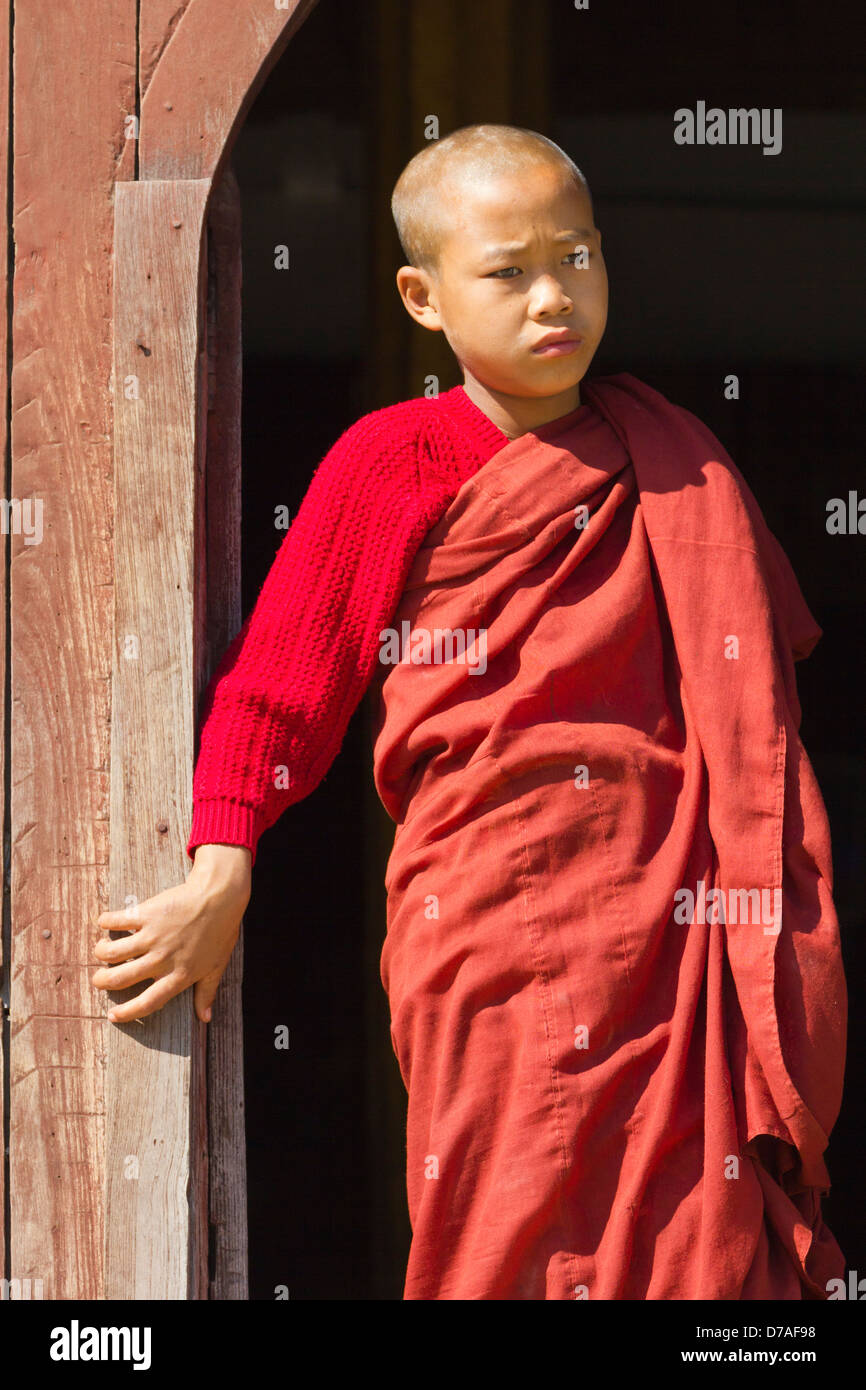 Un giovane monaco dalla finestra in Shwe Yaunghwe Kyaung monastero vicino Lago Inle, Myanmar 6 Foto Stock