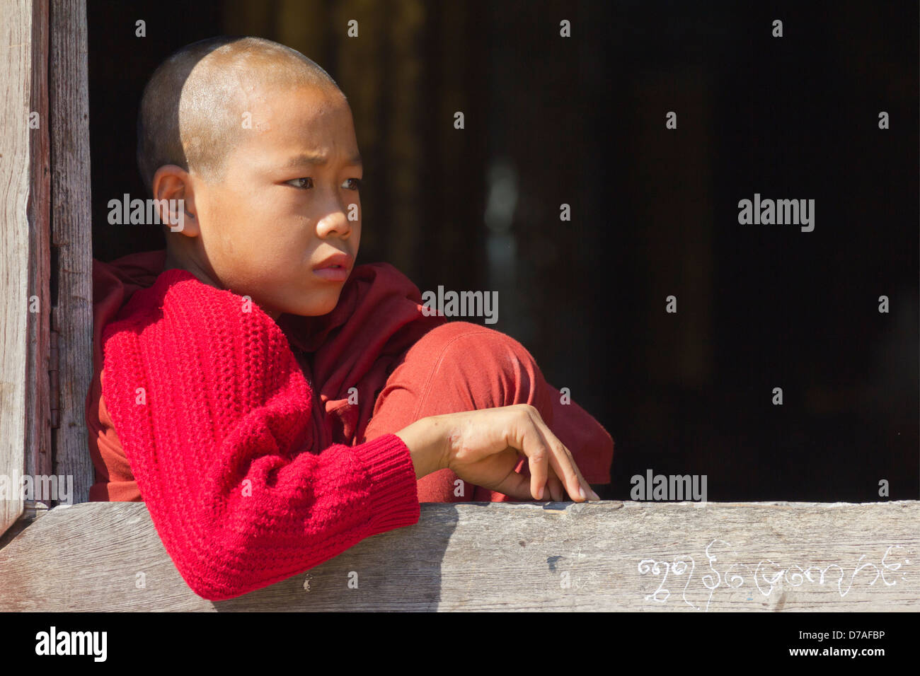 Un giovane monaco dalla finestra in Shwe Yaunghwe Kyaung monastero vicino Lago Inle, Myanmar 3 Foto Stock