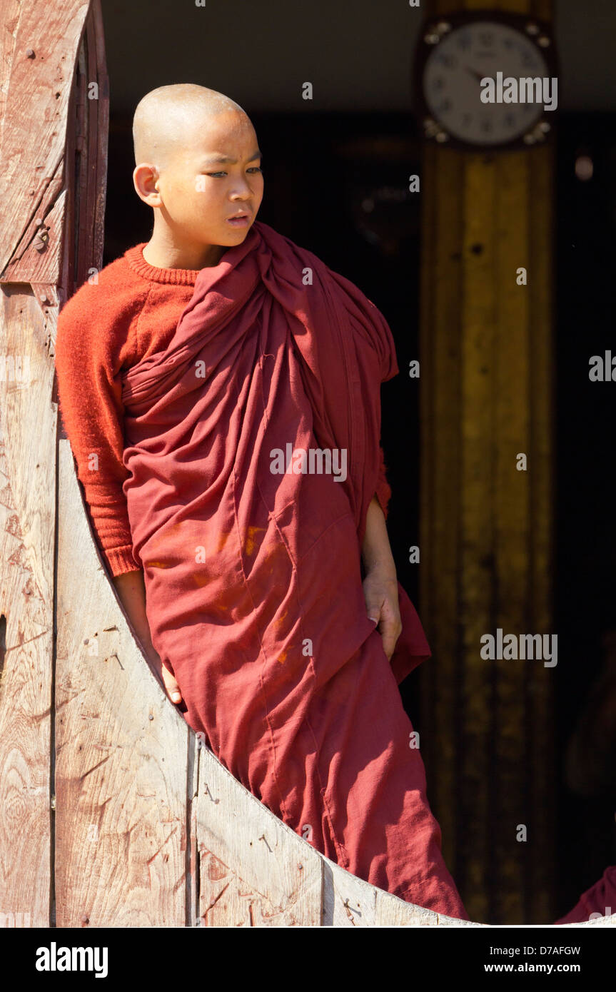 Un giovane monaco dalla finestra in Shwe Yaunghwe Kyaung monastero vicino Lago Inle, Myanmar Foto Stock