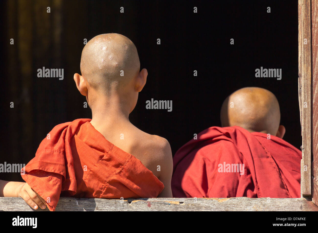 Due giovani monaci dalla finestra in Shwe Yaunghwe Kyaung Monastero, Myanmar 2 Foto Stock