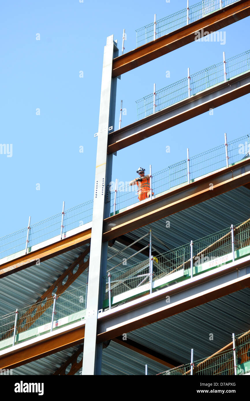 Un lavoratore edile si affaccia su di una nuova build del progetto di alloggiamento. Foto Stock