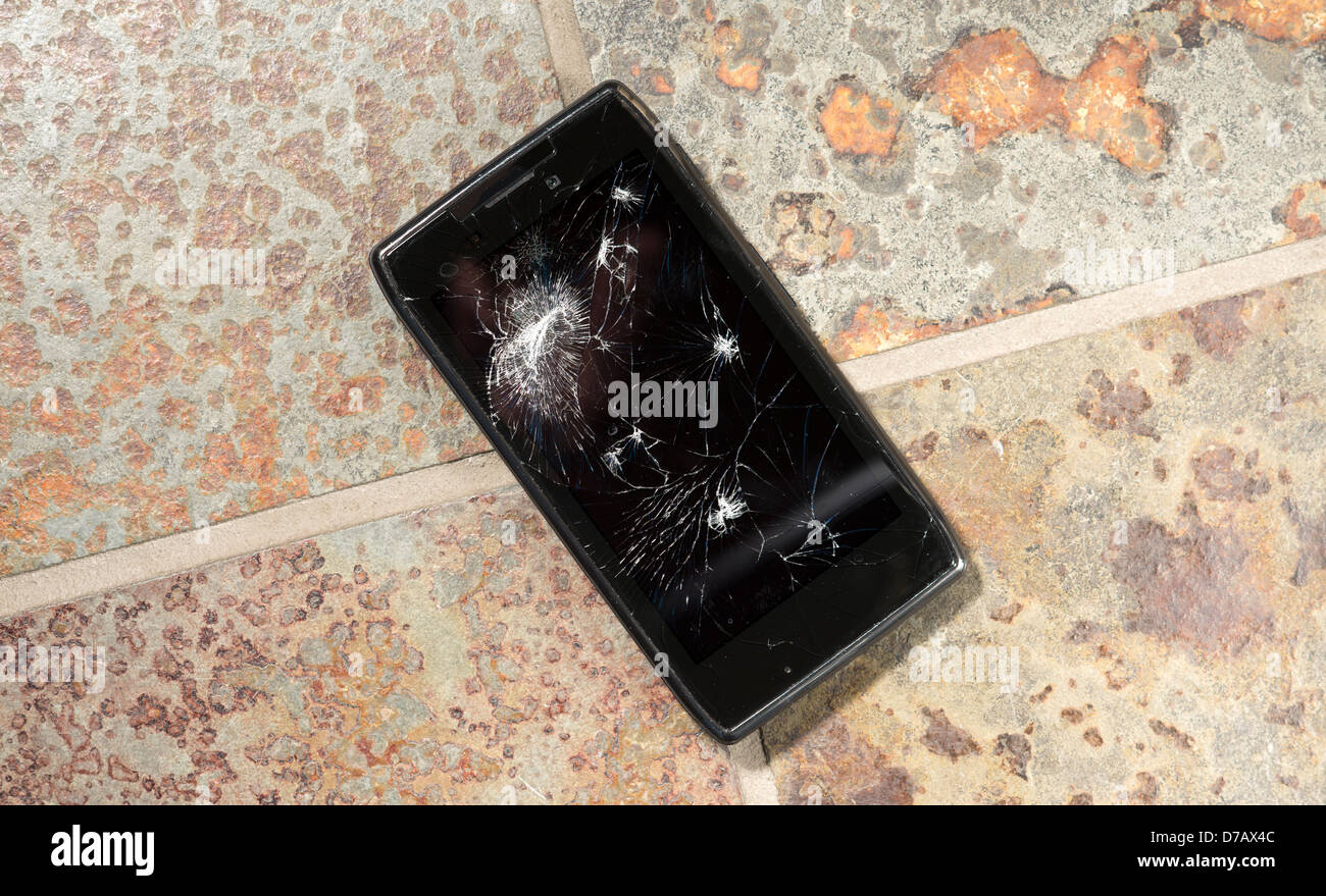 Sceso di smartphone sul pavimento duro con schermo rotto. Foto Stock