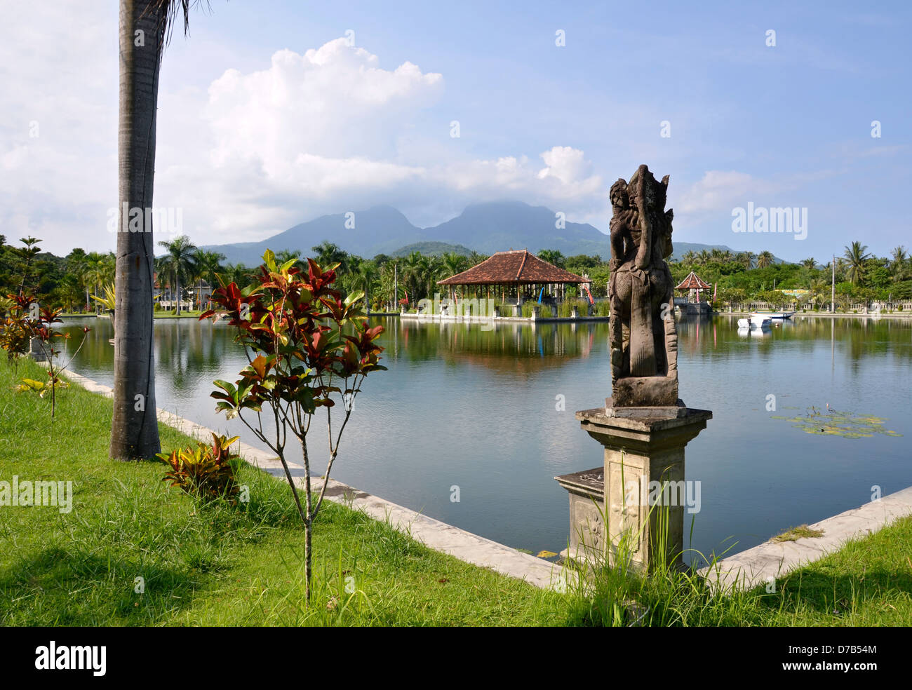 Tirtagangga Taman Ujung acqua palace di Bali. Riparo del tetto con riflesso in acqua contro la montagna Foto Stock