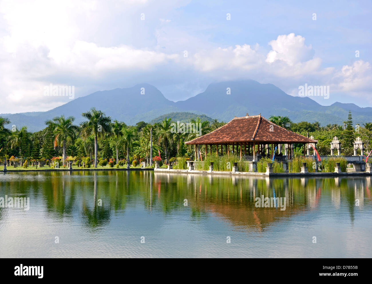 Tirtagangga Taman Ujung acqua palace di Bali. Riparo del tetto con riflesso in acqua contro la montagna Foto Stock