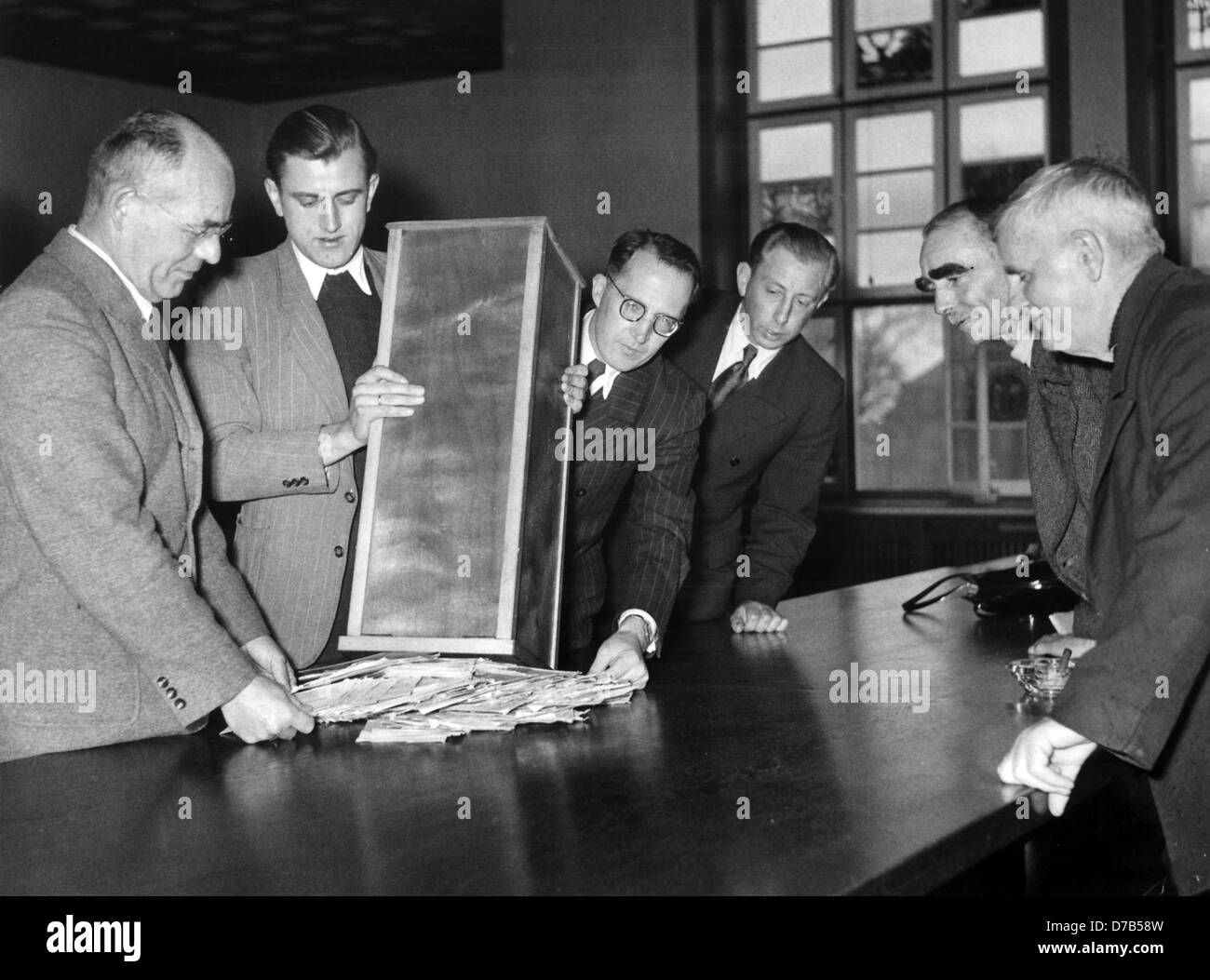 Apertura di una scatola di voto in Pinneberg. Ispettore capo Meyer (sinistra) è venuto a Pinneberg a causa del voto. La foto è stata scattata nel 1953. Primo tempo dopo la Seconda Guerra Mondiale i residenti di Helgoland voto il Parlamento "Helgoland Ausschuss'. Il precedente incombente è stato nominato nel 1952 dal governo di Schleswig-Holstein. La maggior parte del voto 1500 Helgoländer vive ancora oggi sparsi in tutta la Repubblica federale di Germania, così hanno dovuto votare per iscritto. L'Isola di Helgoland sono stati inviati gli elenchi dei 42 candidati, 11 delle quali erano spuntate. Il completato schede sono state conteggiate dell elezione committ Foto Stock