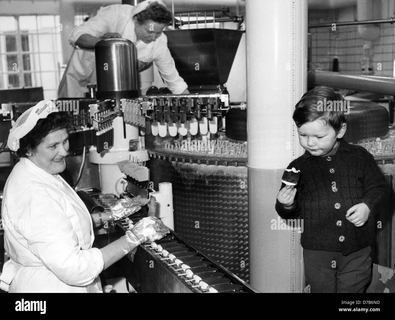 Un ragazzino meraviglie sulla macchina che produce in continuazione il gelato al decimo di febbraio nel 1967. Foto Stock