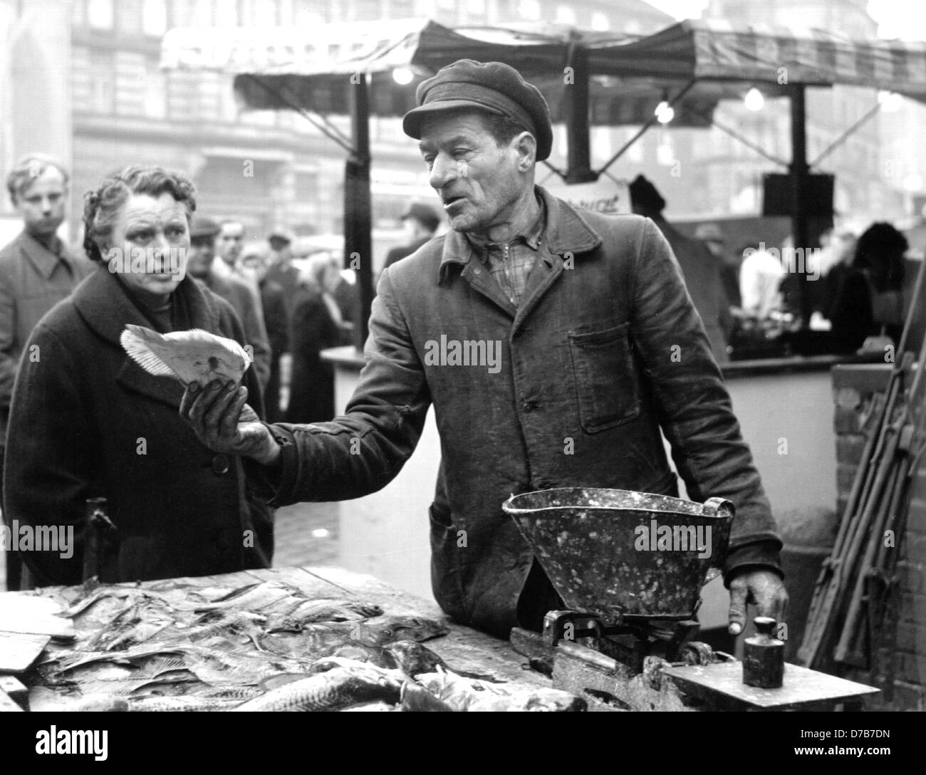 Un venditore offre un passera di mare sul mercato del pesce di Altona Amburgo. Citata in un documento per la prima volta nel 1664, essa ha ricevuto una organizzazione comune di mercato nel 1710. Fotografato negli anni cinquanta. Foto Stock