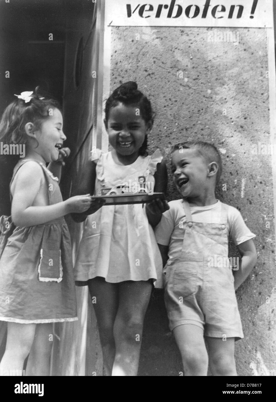 Tre bambini, uno di essi è la figlia di un colorato soldato alleato e una donna tedesca e una cosiddetta 'occupazione bambino', giocare insieme allegramente (foto scattata negli anni cinquanta). Foto Stock