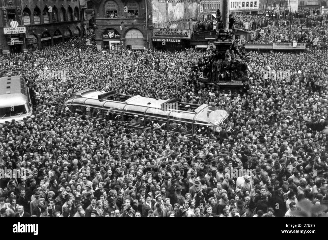 Entusiasmo per la squadra nazionale di calcio tedesca di Monaco di Baviera il 6 Luglio nel 1954. Migliaia di persone hanno affollato tutto il tour bus contenenti le mogli e fidanzate dei giocatori. La Germania ha svolto un sensazionale corrispondono al 1954 FIFA World Cup finale e vince 3:2 contro l'Ungheria due giorni fa, vincendo il titolo per la prima volta. Foto Stock