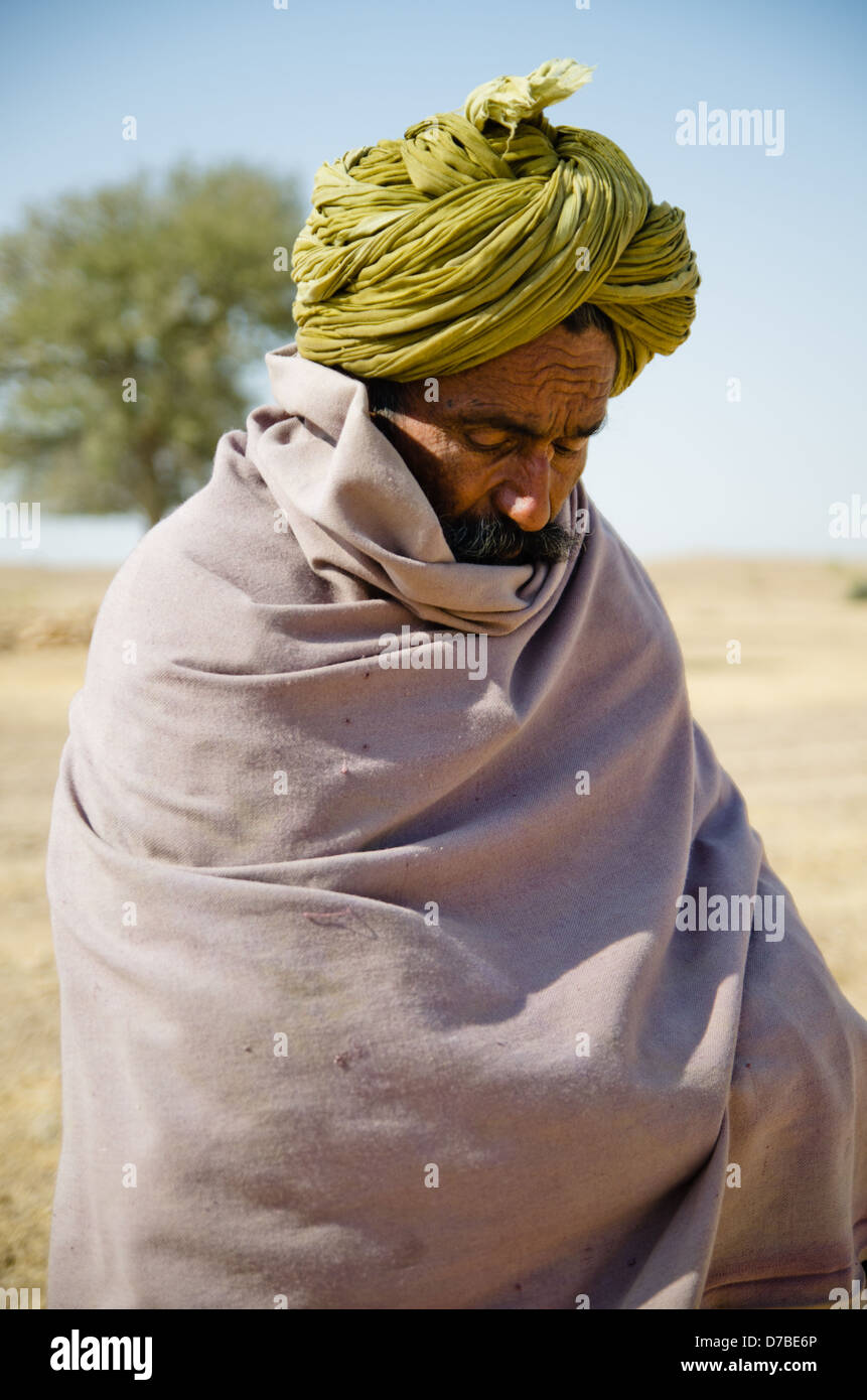 RAJASTHAN, India - 11 gennaio: Pastore pascere il suo gregge prende un momento di riposo il 11 gennaio 2013 in Rajasthan. Foto Stock