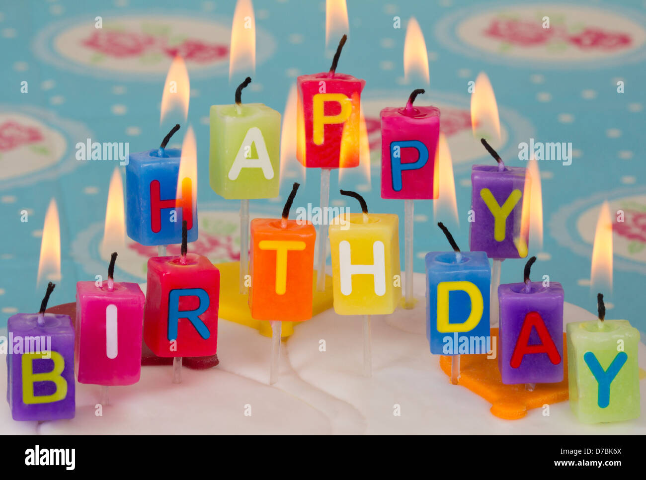 Buon compleanno candeline sulla torta di compleanno con blu e sfondo floreale. Foto Stock