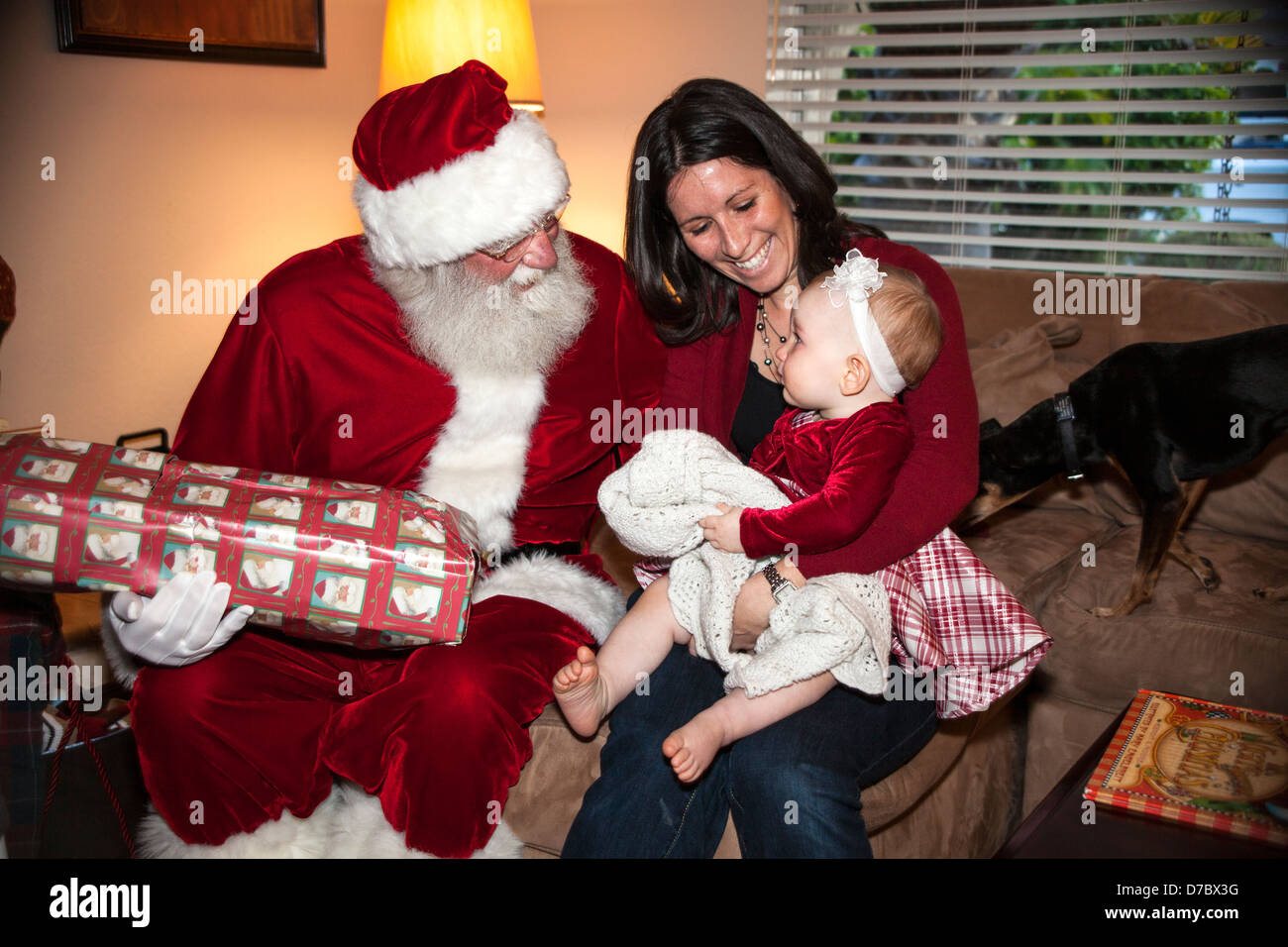 Santa Claus parlando a madre tenendo la sua bambina. Foto Stock