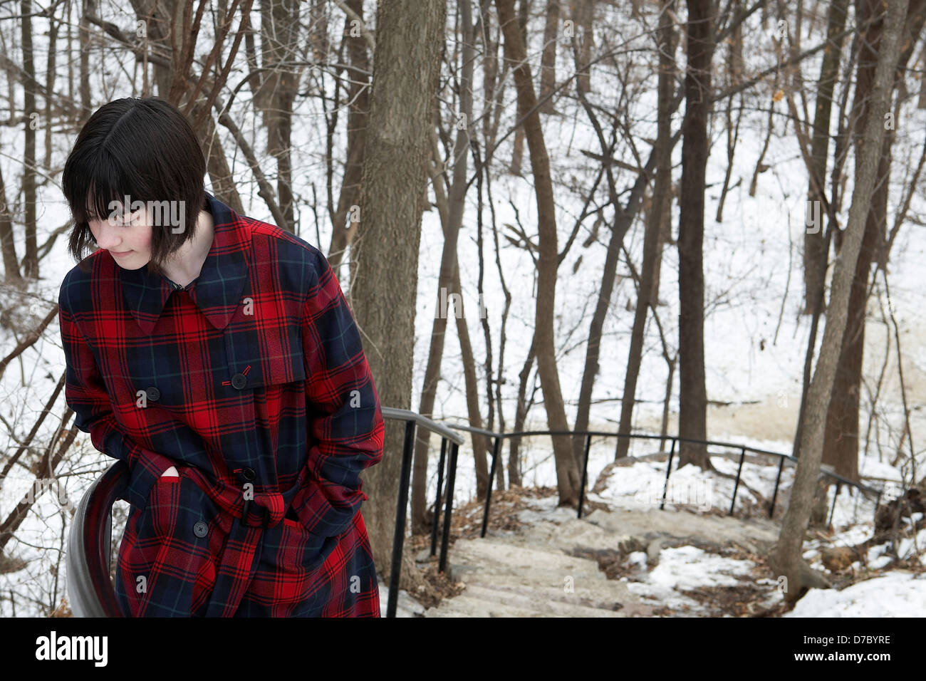 Teen ragazza camminare su per le scale in coperta di neve park Foto Stock