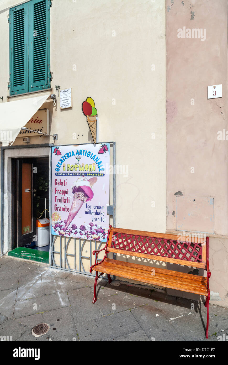 Panca in legno e gelateria nelle antiche lungomare del centro storico di Alghero, Sardegna Foto Stock