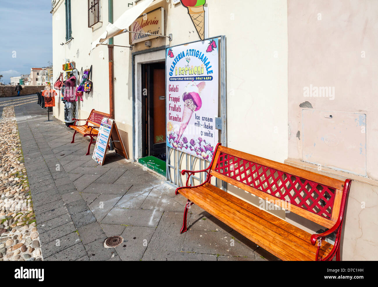 Panca in legno e gelateria nelle antiche lungomare del centro storico di Alghero, Sardegna Foto Stock