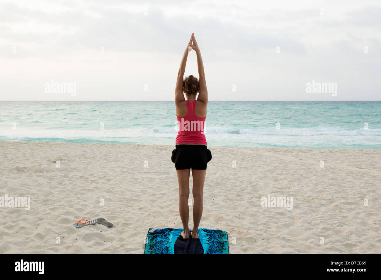 Messico, Playa del Carmen, giovane donna a praticare yoga sulla spiaggia al sorgere del sole Foto Stock