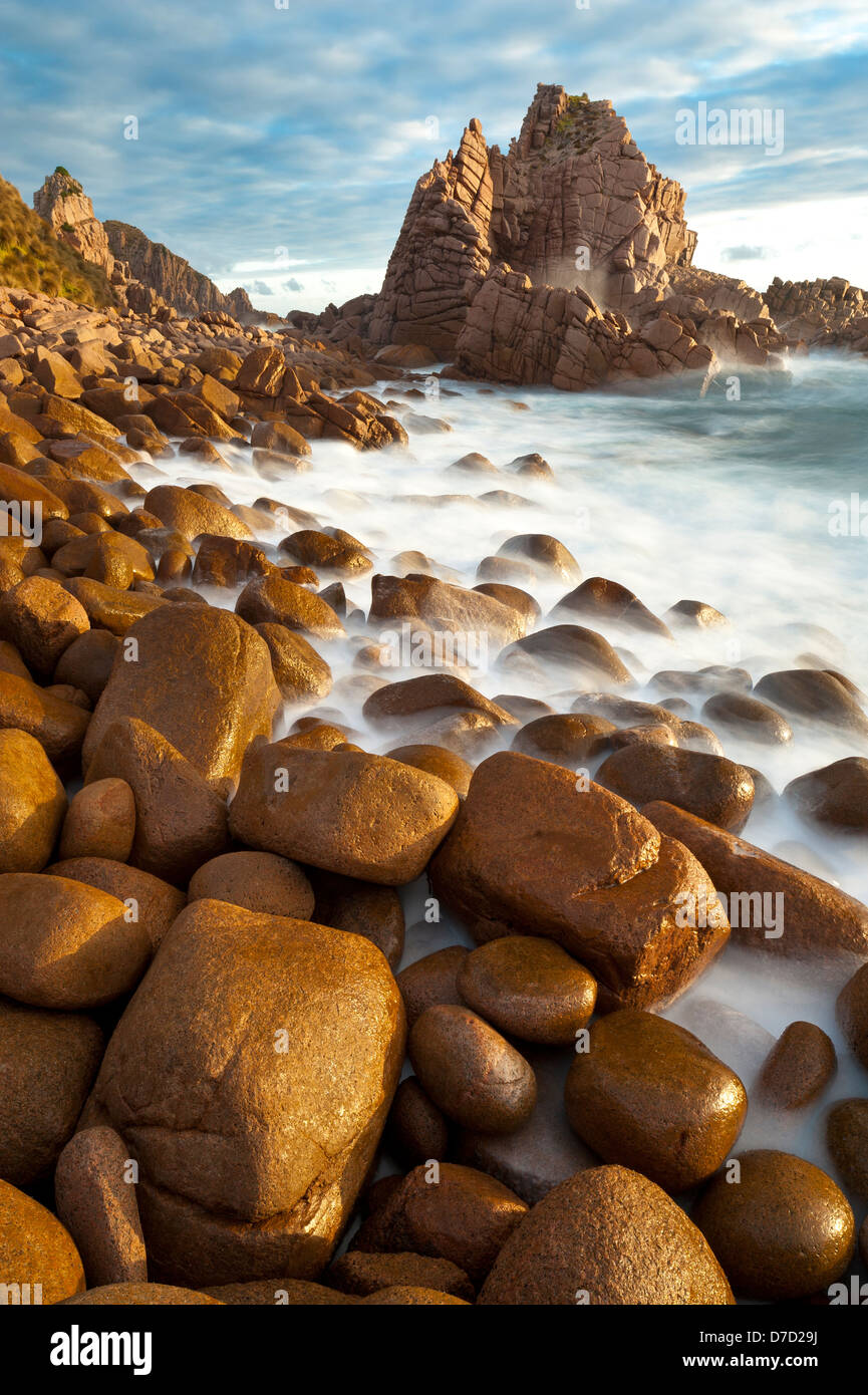 La spiaggia rocciosa al di pinnacoli di Cape Woolamai sul circuito di Phillip Island al tramonto Foto Stock