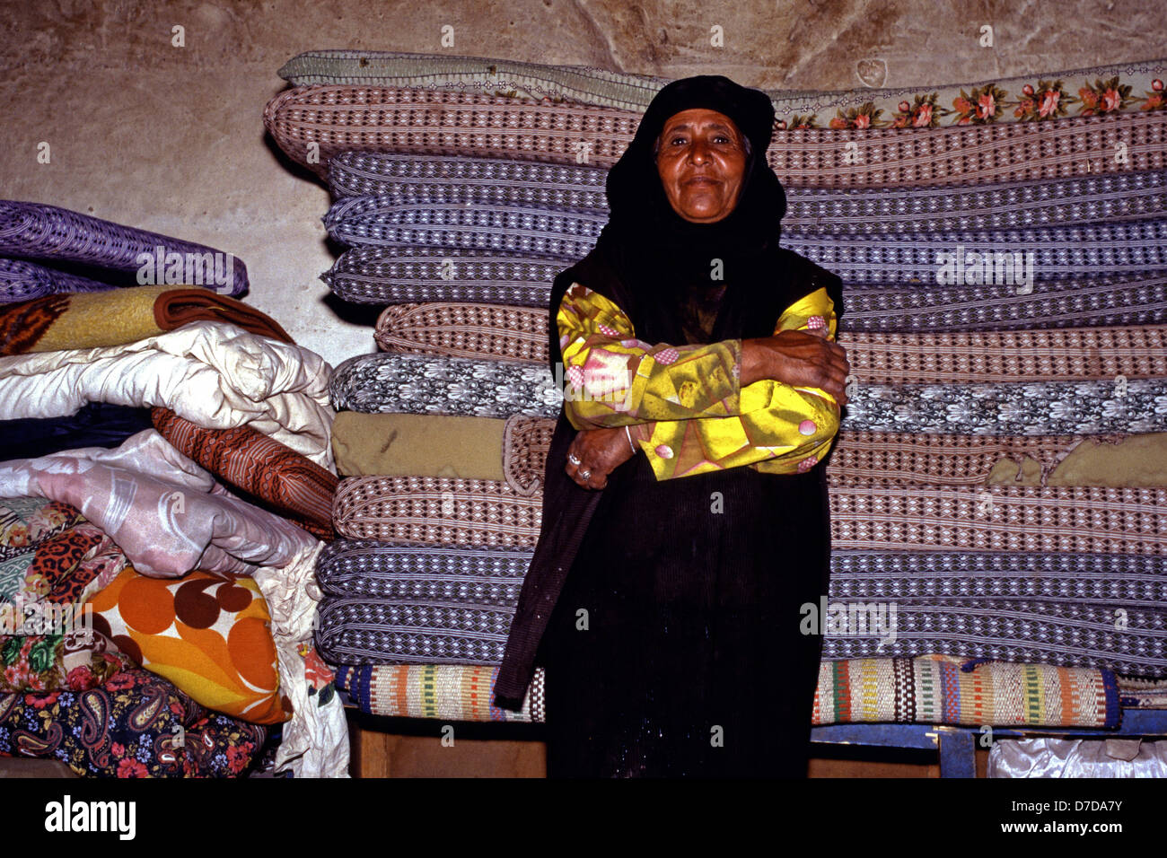 Un'anziana donna beduina dalla tribù Bedul Uno della tribù Huwaitat che storicamente hanno vissuto in Petra indossando abiti tradizionali all'interno di una grotta residence tagliata nella roccia di Wadi Musa vicino a Petra Giordania Foto Stock