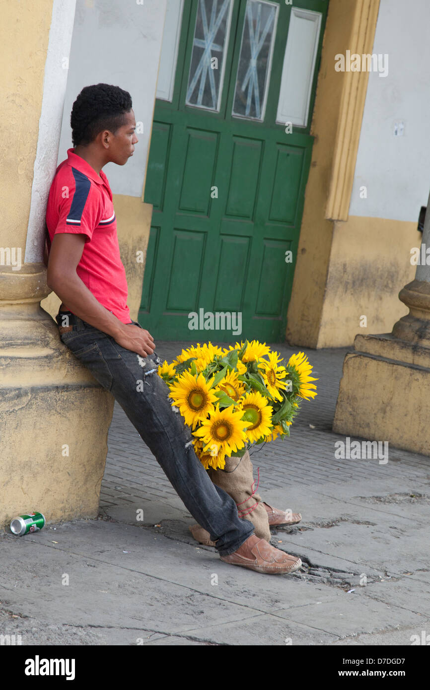 Ragazzo che vendono fiori nelle strade di La Habana Foto Stock