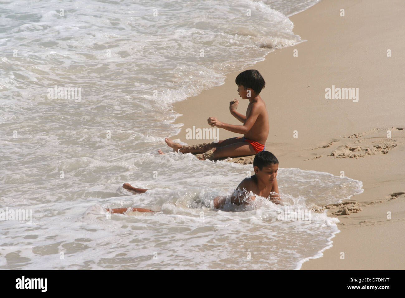 Due ragazzi di divertirsi con le onde di rotolamento a Leme Beach, su una soleggiata giornata autunnale. Rio de Janeiro, Brasile Foto Stock