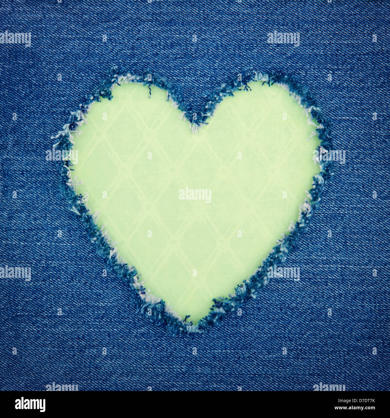 Vendemmia verde forma di cuore per una copia spazio strappato dal blu denim jeans tessuto, amore romantico concetto sfondo Foto Stock