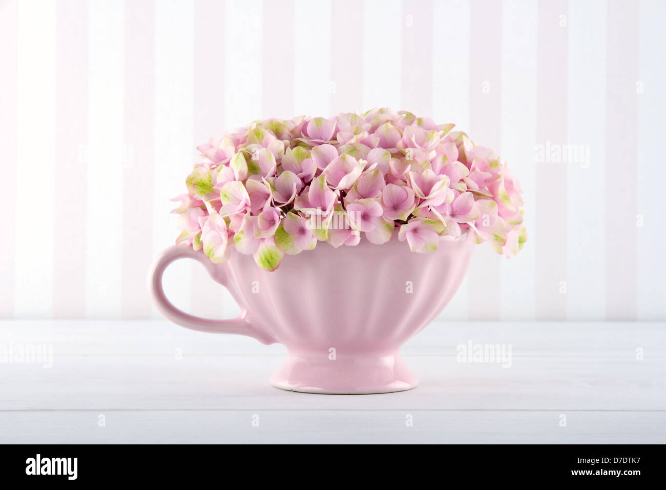 Rosa fiori di ortensie in uno squallido chic mug su vintage sfondo con spazio di copia Foto Stock