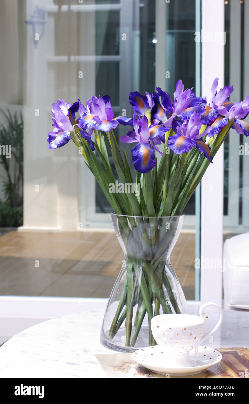 Bella iride artificiale fiori in un vaso di vetro Foto Stock