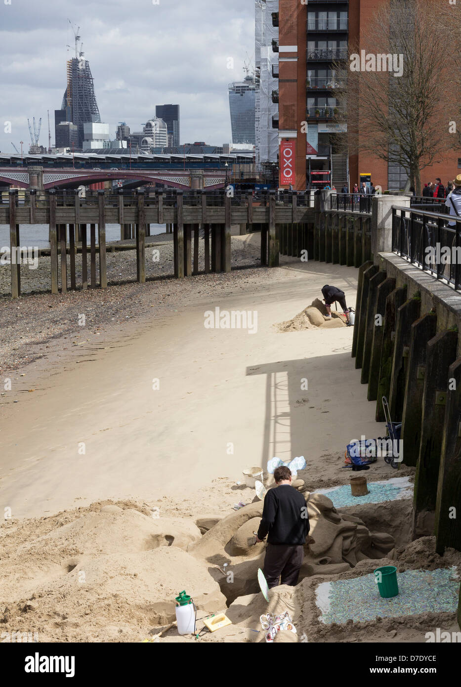 Artisti la creazione di sculture di sabbia al Fiume Tamigi spiaggia di Gabriels Wharf, London Foto Stock